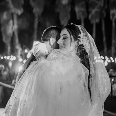 a bride hugging her groom in a black and white photo