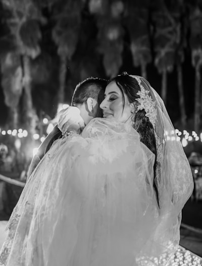 a bride hugging her groom in a black and white photo