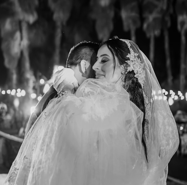 a bride hugging her groom in a black and white photo