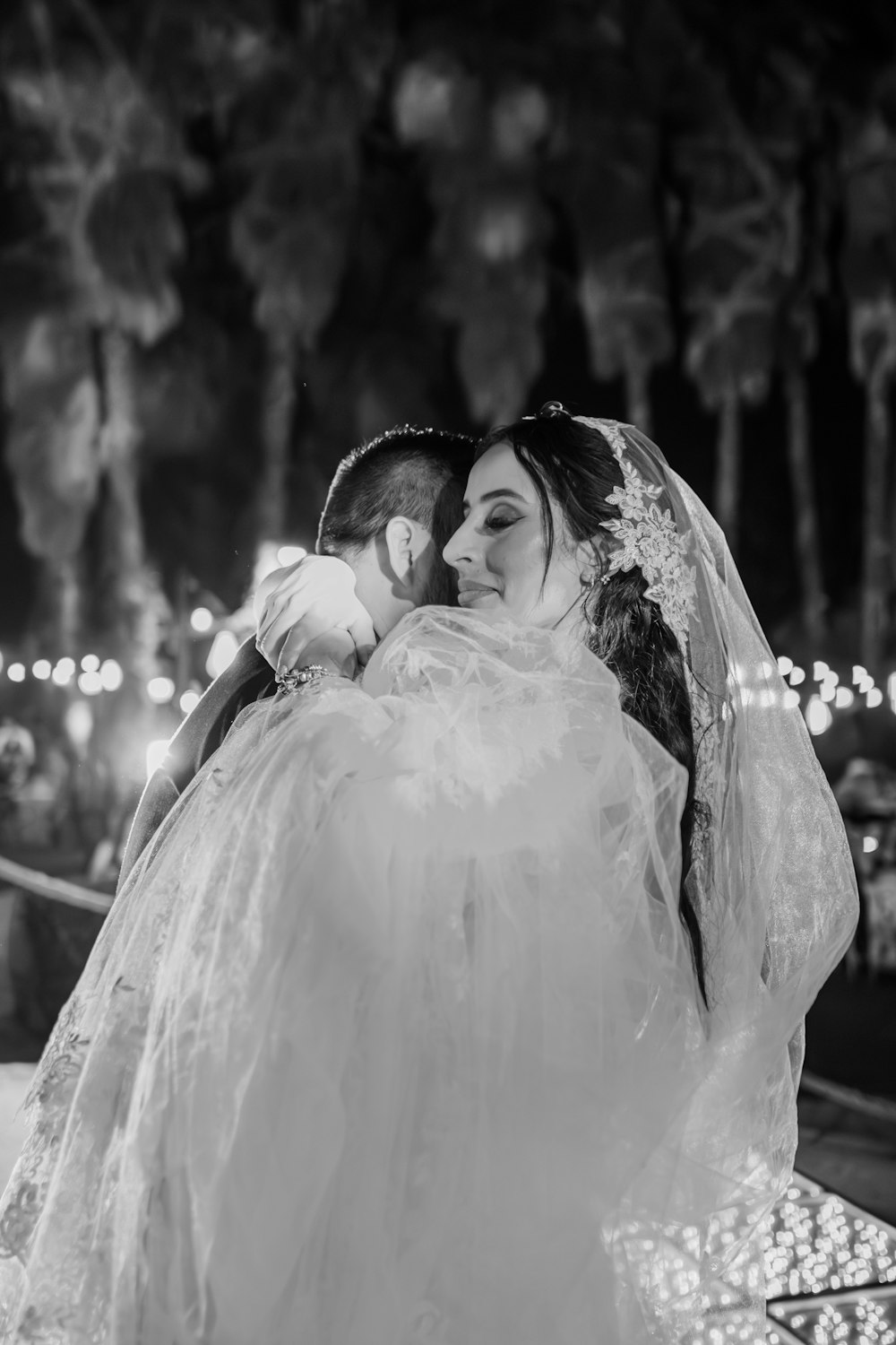 uma noiva abraçando o noivo em uma foto em preto e branco