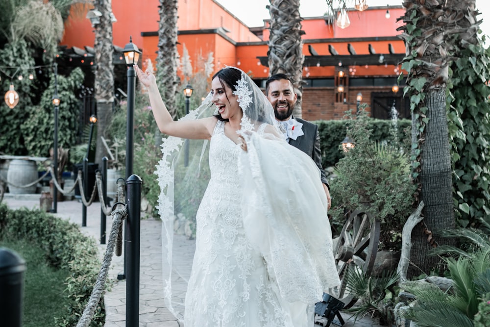 a bride and groom walking down the street