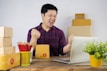 A cheerful person happily unboxing a package of discounted products at home.