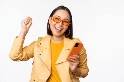 a woman in a yellow jacket holding a cell phone