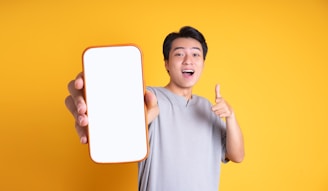 A satisfied customer giving a thumbs up while using a smartphone.