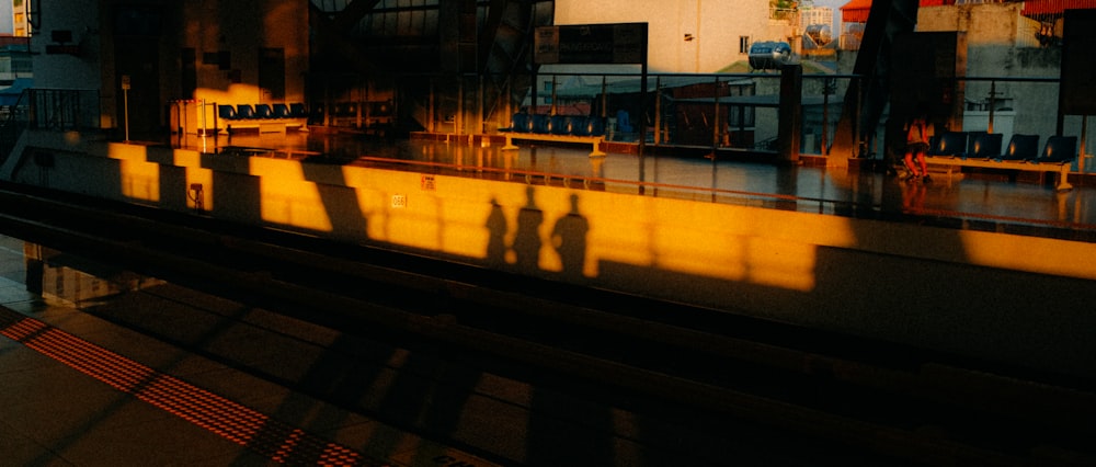 the shadow of two people on the side of a train