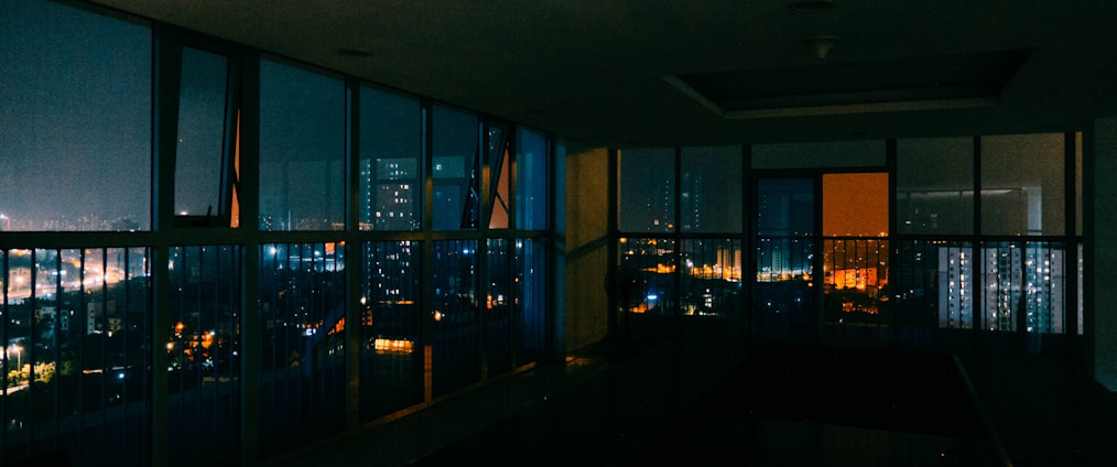 A sleek, dark-themed office space with cityscape views of Nairobi at dusk, reflecting a private and exclusive atmosphere.