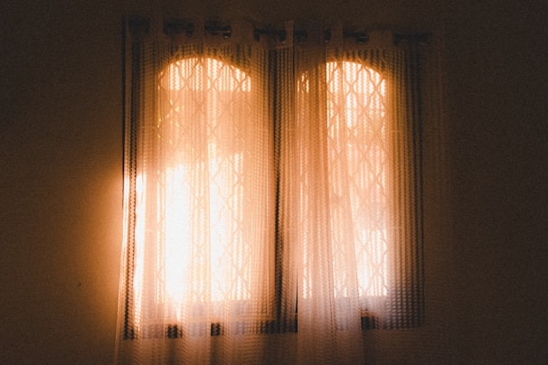 Bright kitchen window adorned with patterned decorative curtains adding warmth and charm.