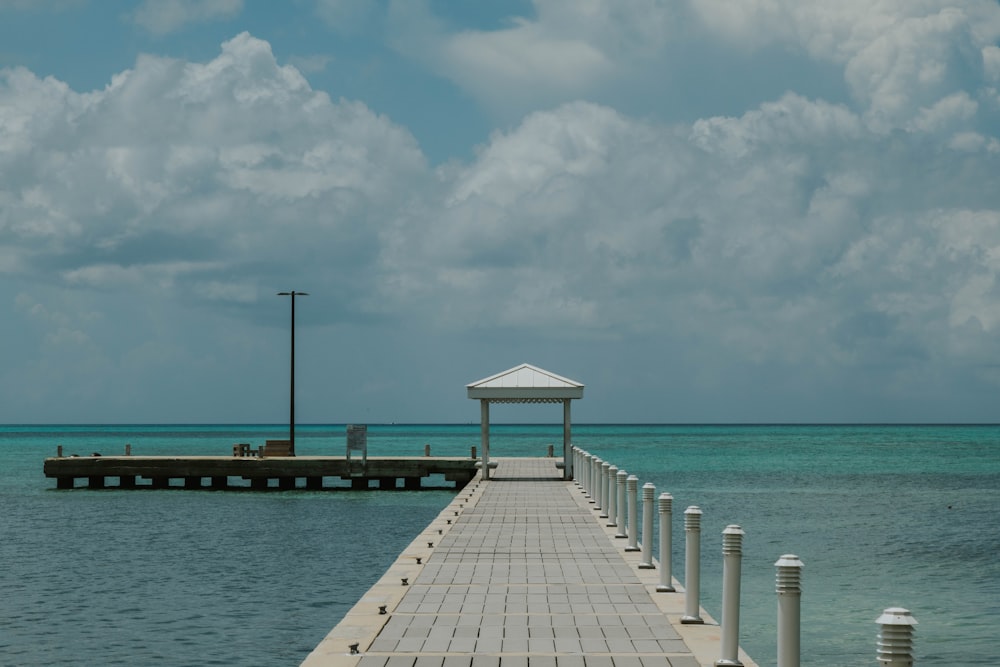 a pier with a gazebo on a cloudy day