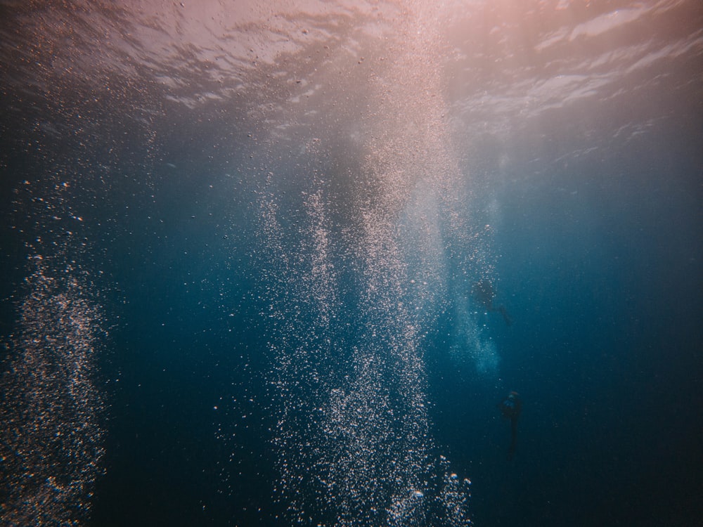 eine Person, die im Ozean unter Wasser schwimmt