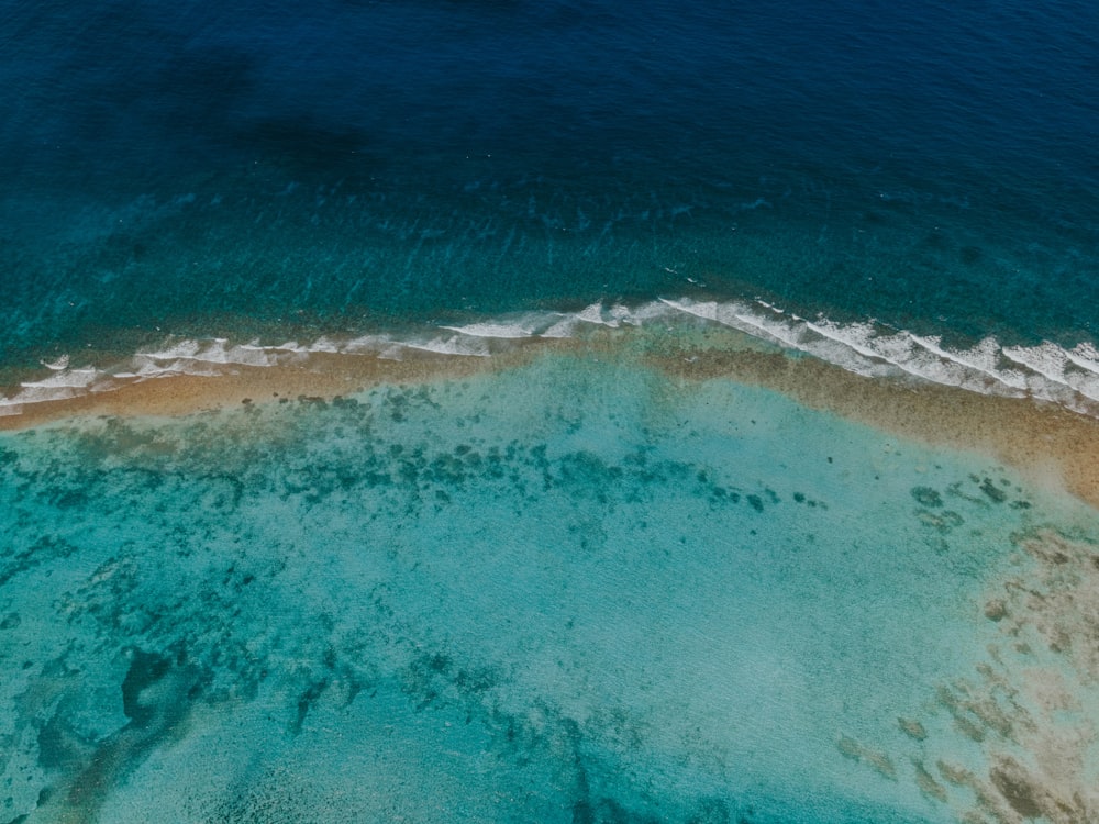 an aerial view of a beach with blue water