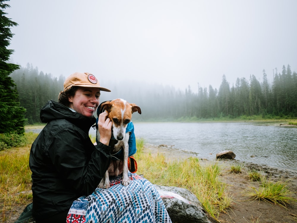 a person sitting on a rock with a dog