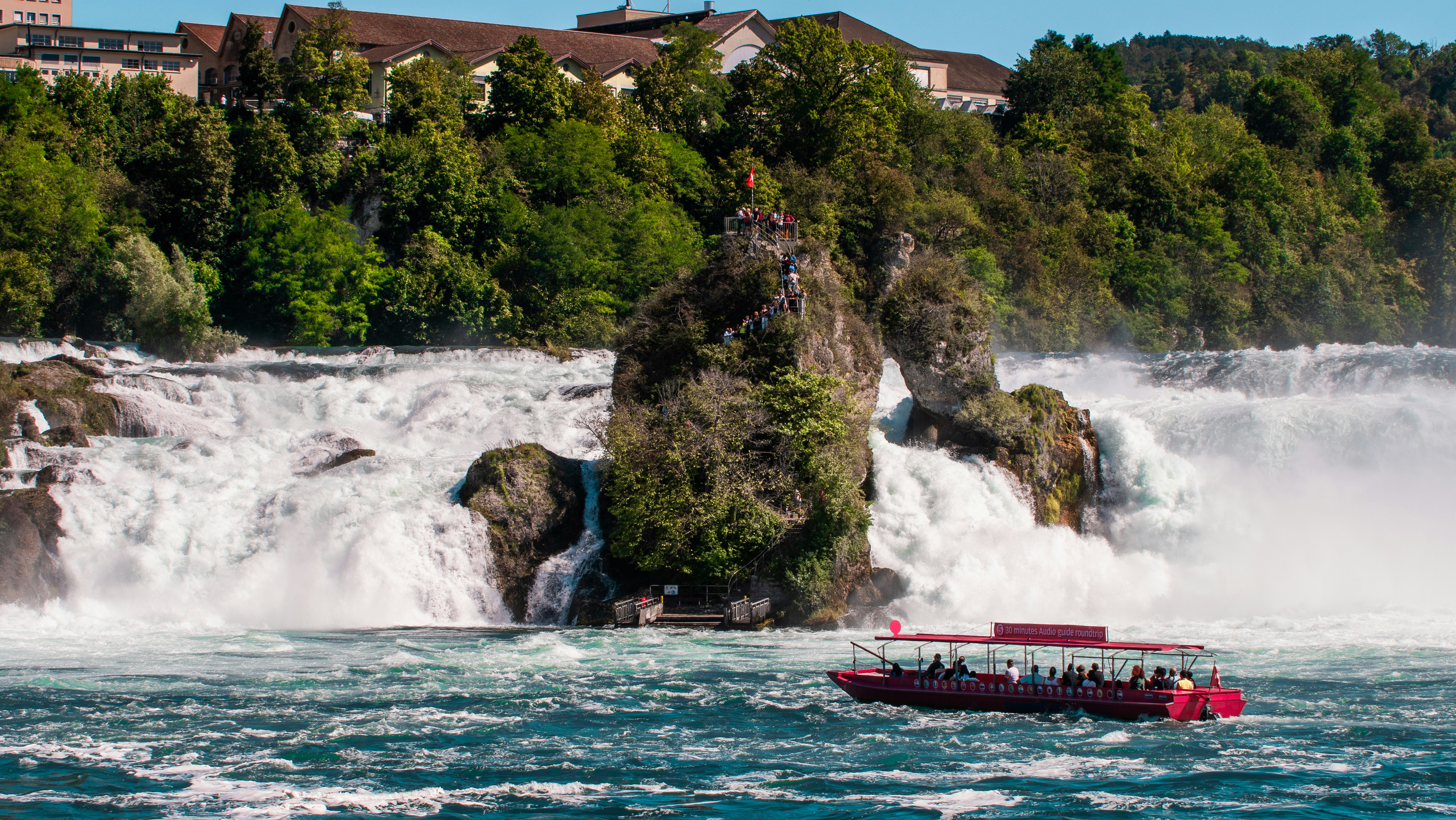 a boat is in the water near a waterfall
