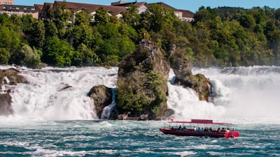 a boat is in the water near a waterfall