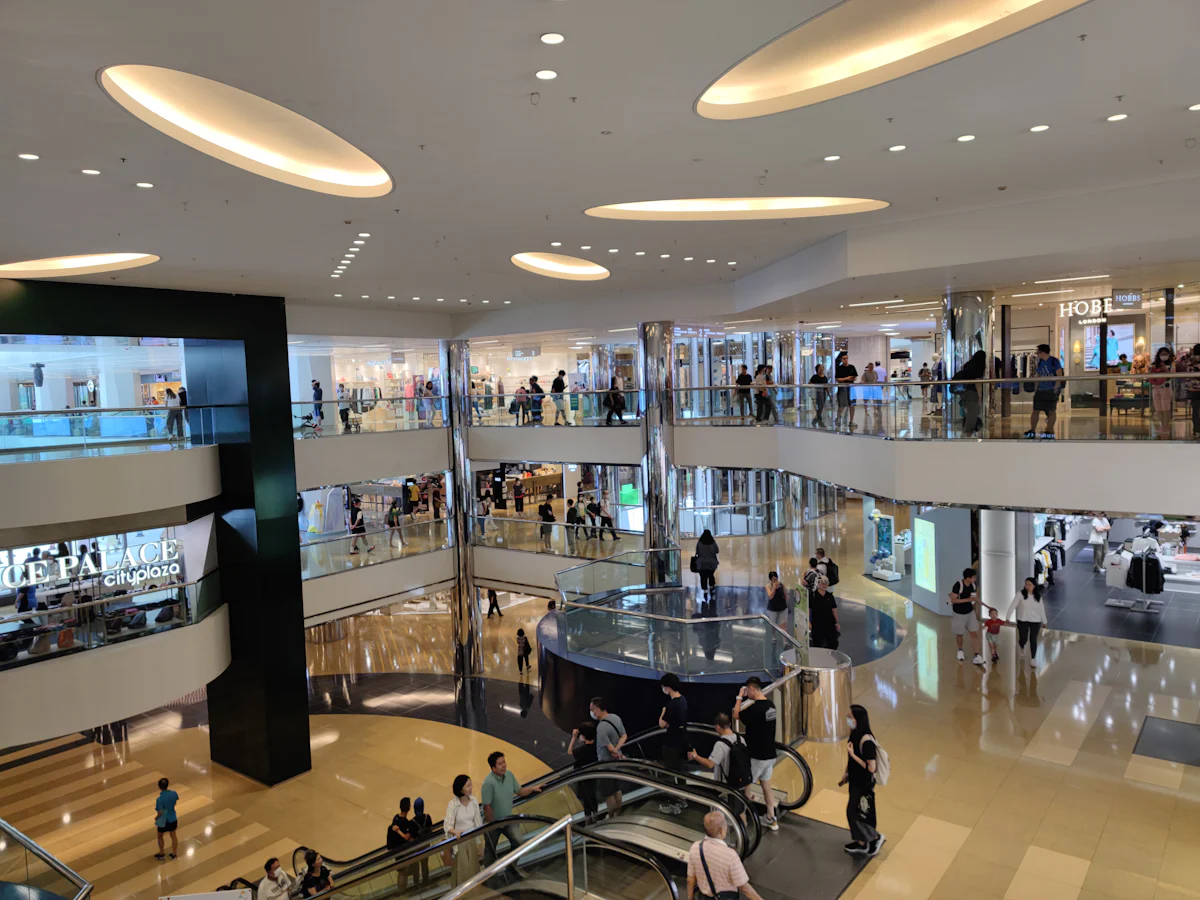 Shopping movimentado, com pessoas circulando entre as lojas