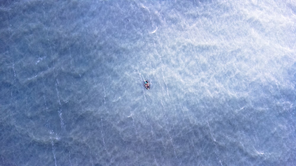 a small boat floating in the middle of the ocean