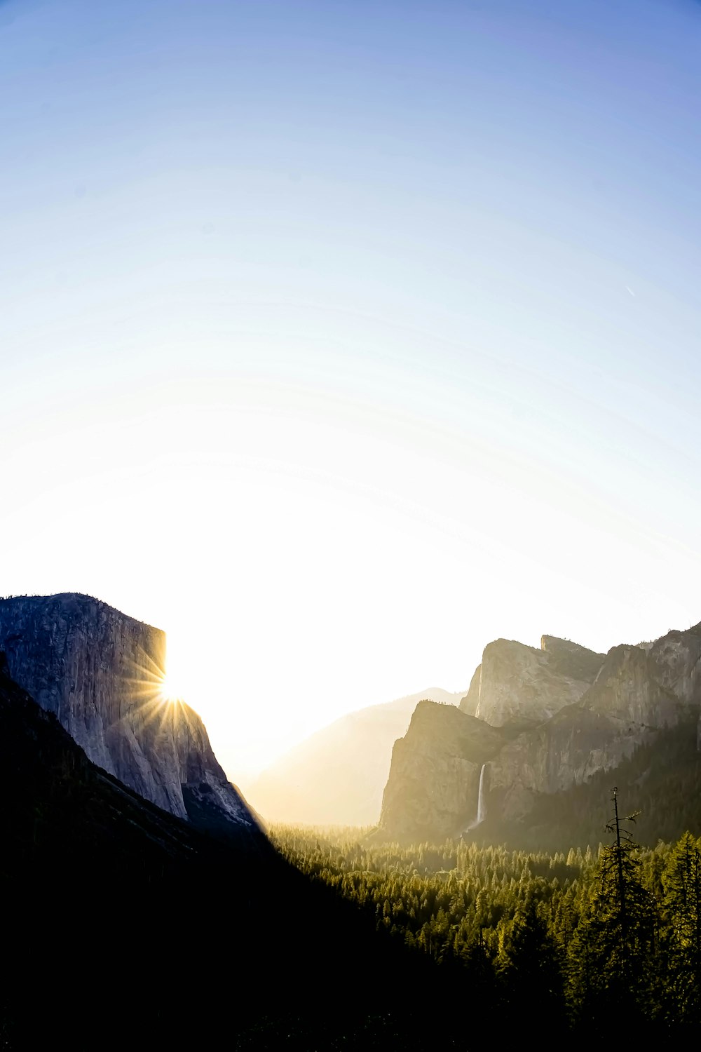 the sun shines brightly through the mountains