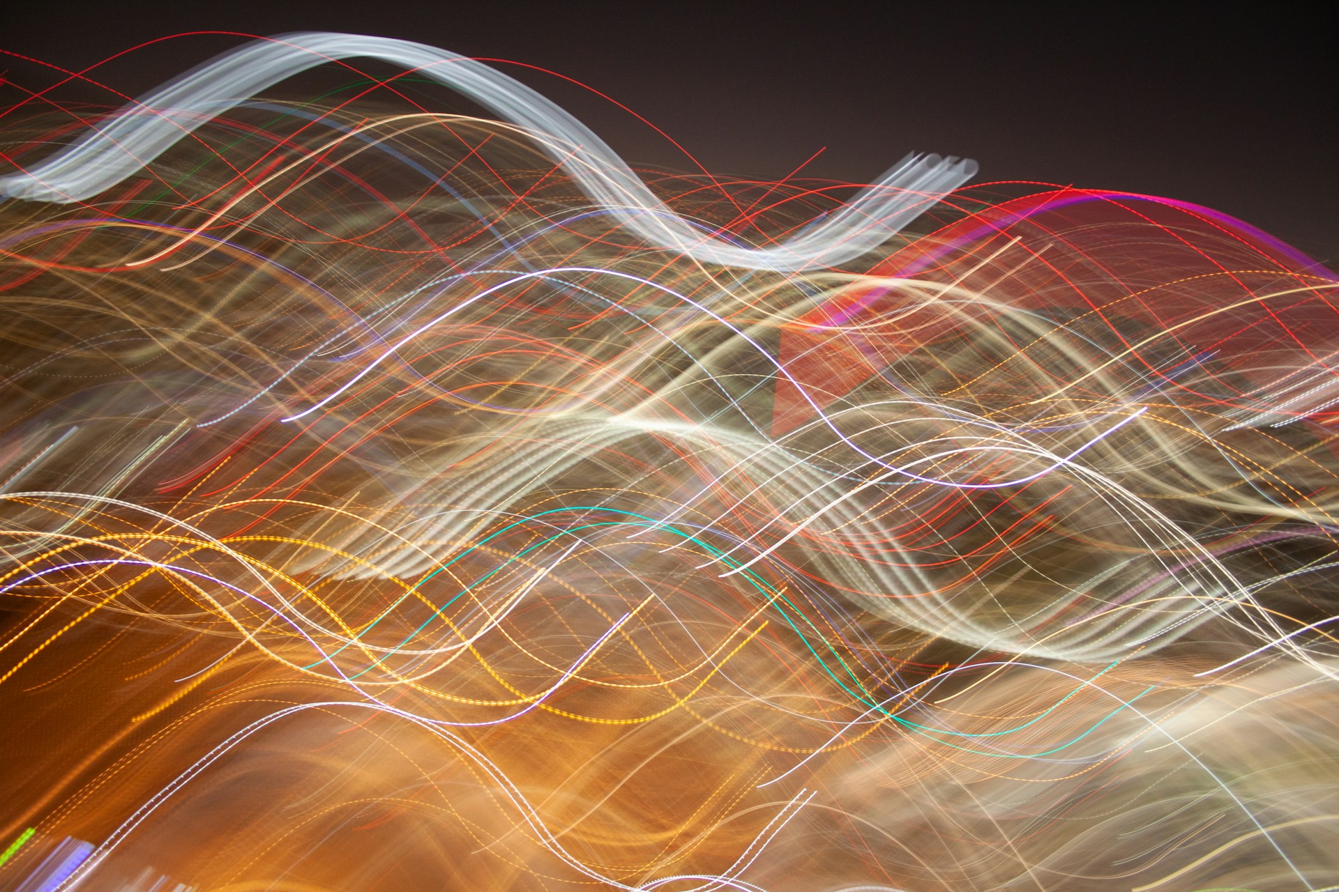 An artistic blend of vibrant light trails flowing across the screen, creating a sense of energy and uniqueness.