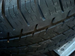 Close-up view of a tire, showing the intricate tread patterns and texture of the rubber surface. The image highlights the grooves and design intended for traction and durability.