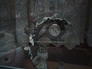 Close-up of a wall clock with a vibrant owl illustration hanging above a wooden desk.