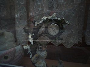 Close-up of a wall clock with a vibrant owl illustration hanging above a wooden desk.