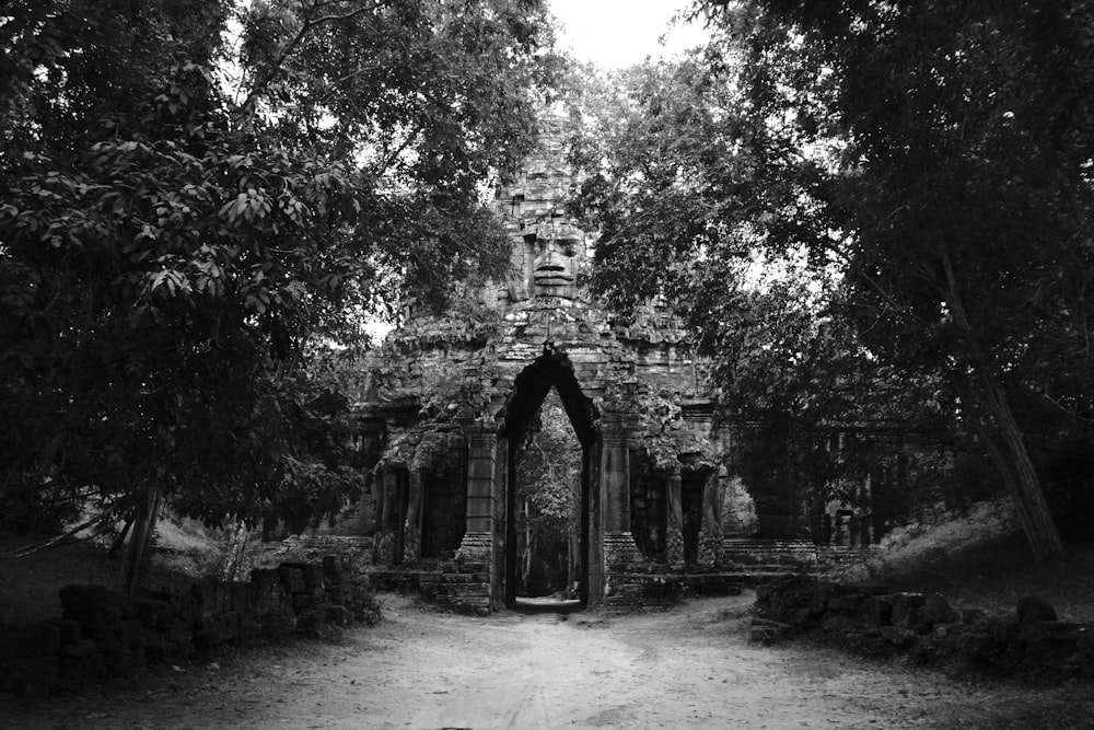 a black and white photo of a stone building surrounded by trees