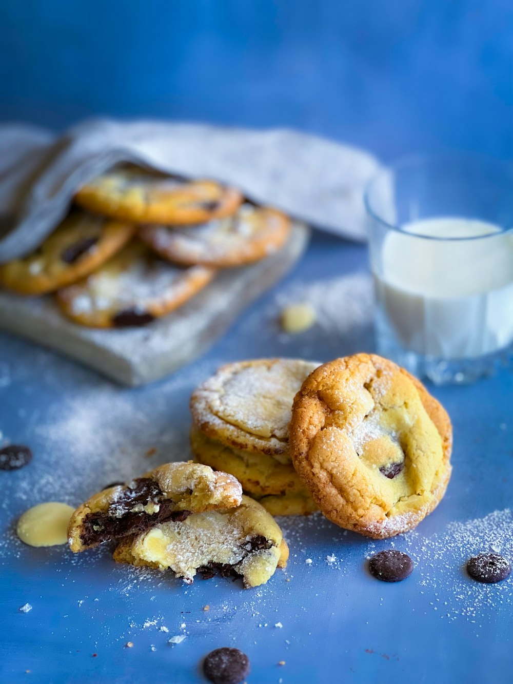 a blue table topped with cookies and a glass of milk