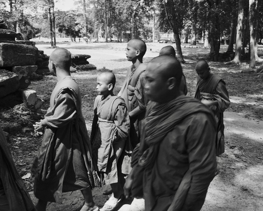 a group of monks walking down a dirt road