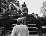 A group of travelers sharing a quiet moment during a ritual ceremony beside ancient stone ruins.
