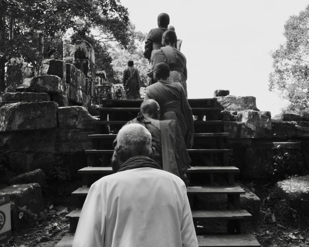 a black and white photo of a group of people walking up some steps