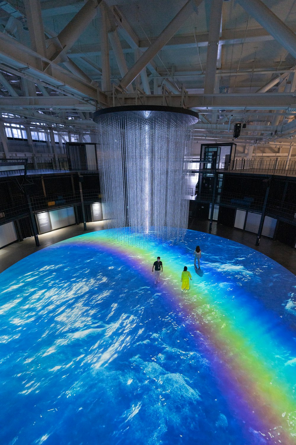 two people standing in front of a rainbow fountain