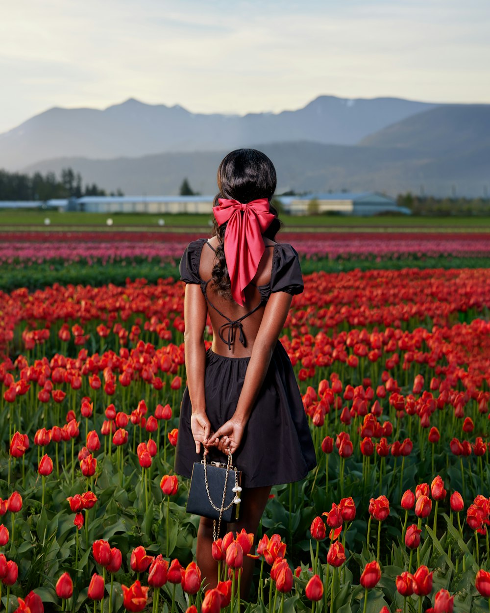 a woman standing in a field of red tulips