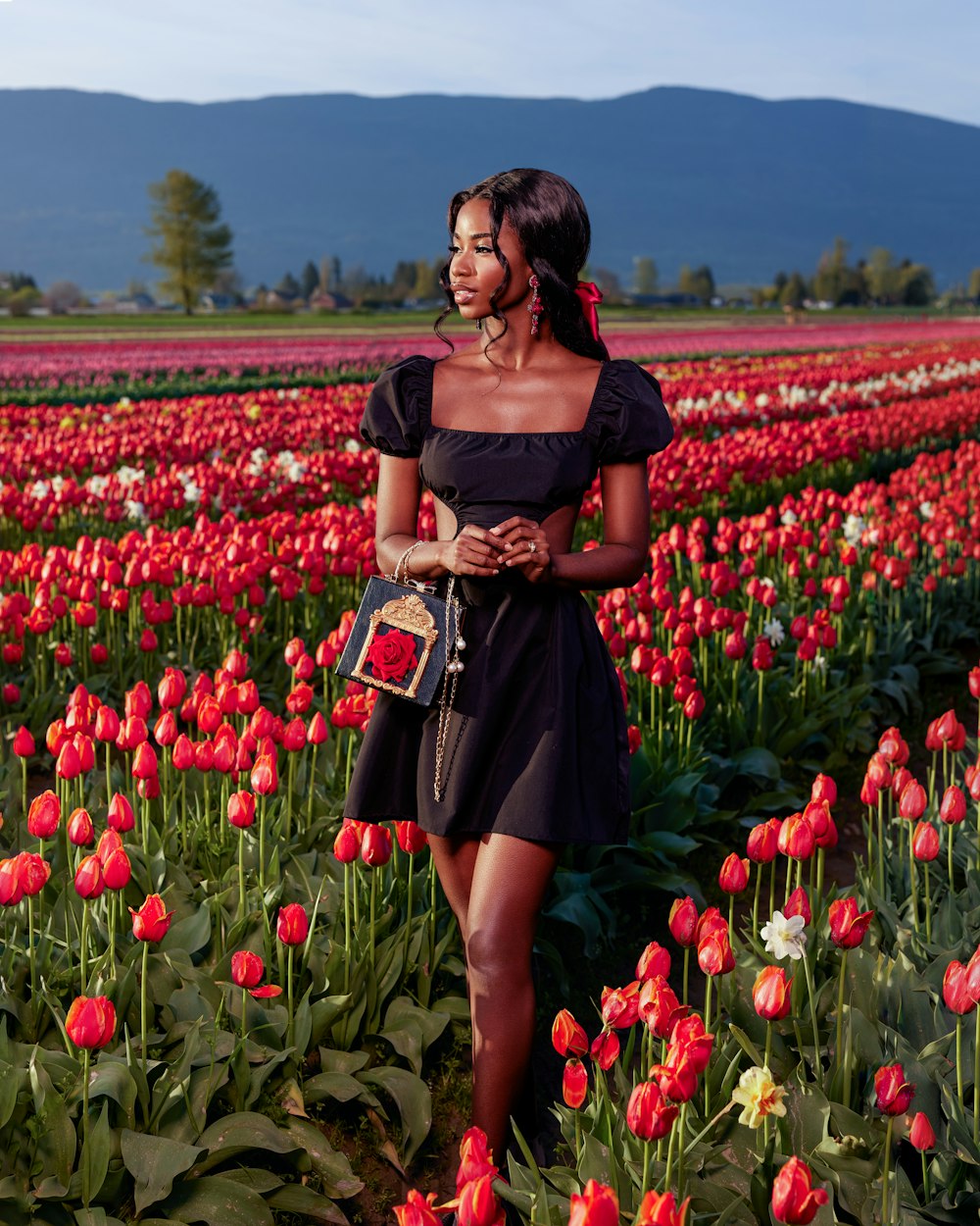 a woman standing in a field of red tulips
