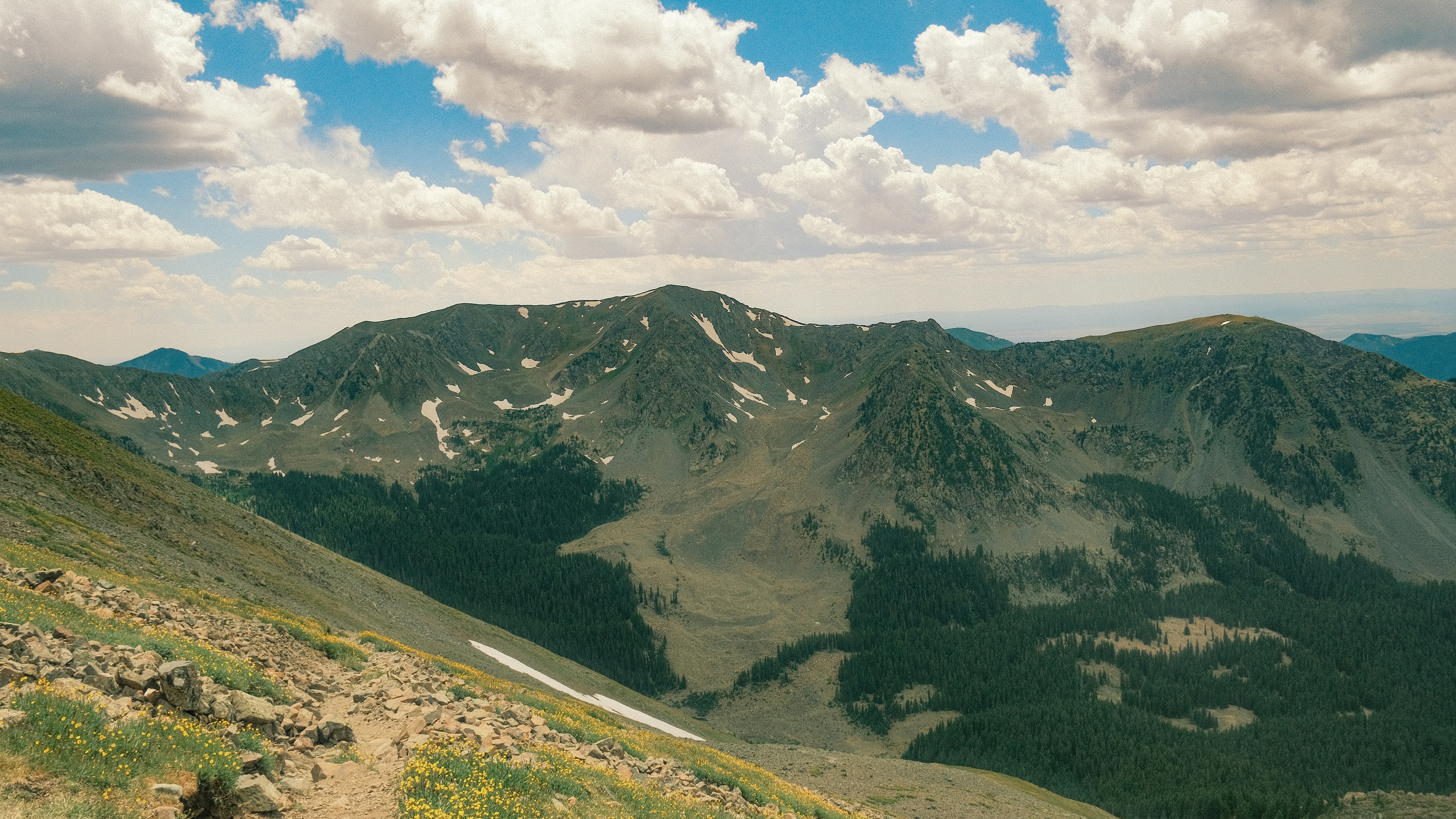 a view of a mountain range with a few clouds in the sky