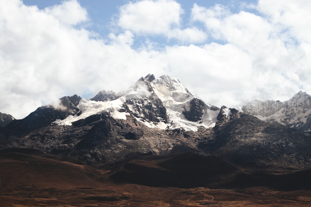 a mountain range with snow capped mountains in the background