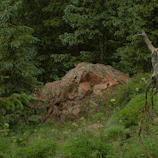 Quiet rocky outcrop near the Coubiou hamlet surrounded by lush greenery.