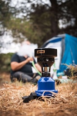 Close-up of a sleek portable air pump in use on a camping site.