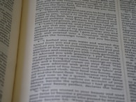 A close-up view of an open book displaying printed text in a column layout. The text appears to be a narrative or a passage from literature, with organized formatting and clear print.
