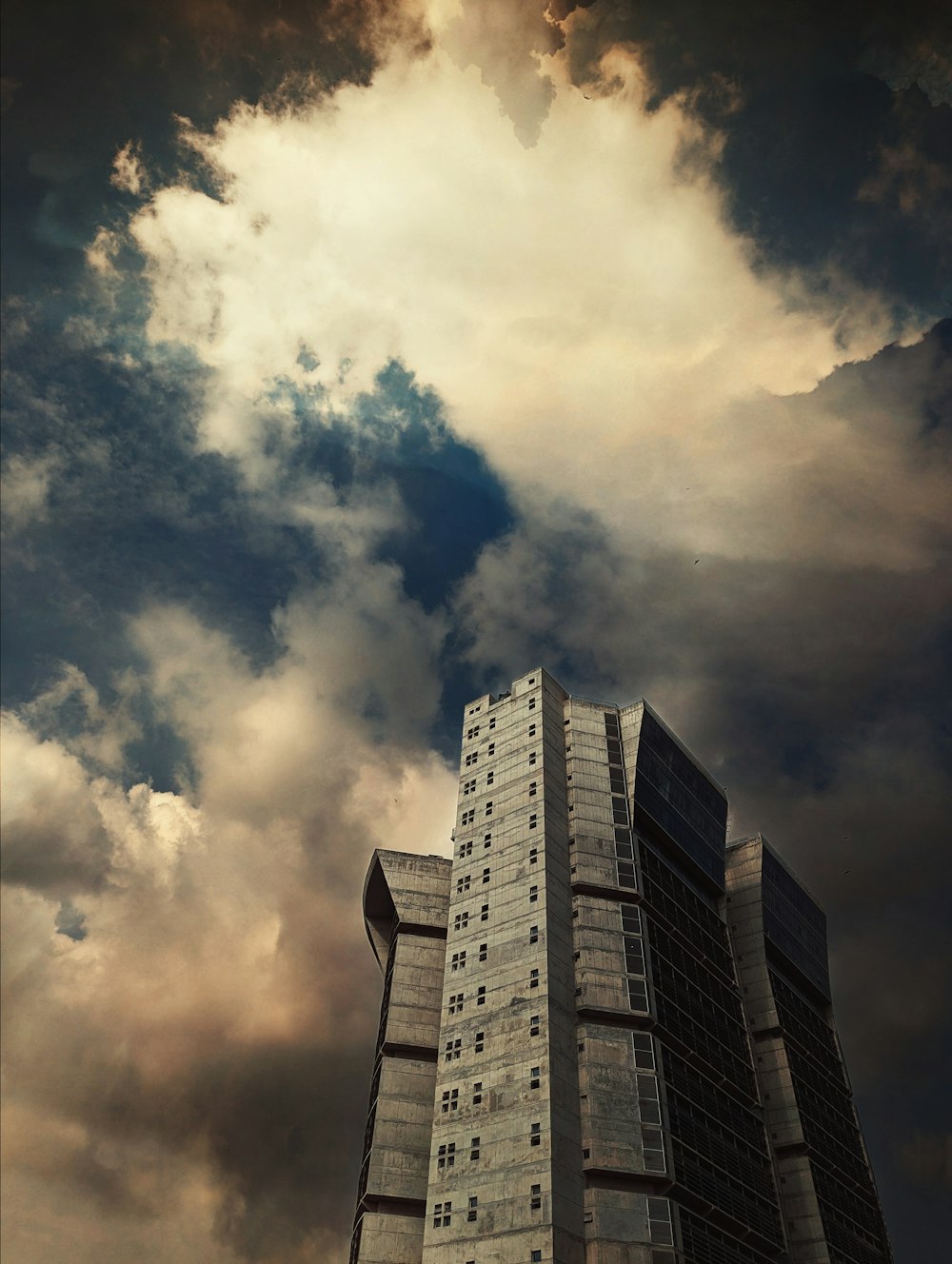 a tall building sitting under a cloudy sky