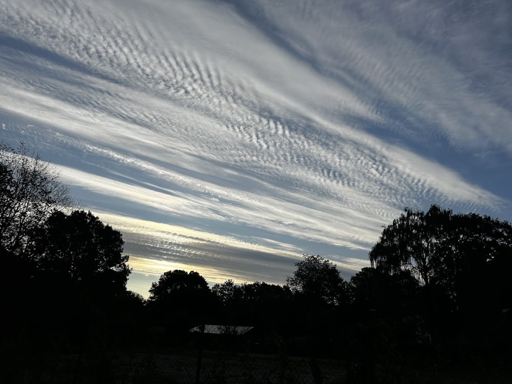 O céu está cheio de nuvens e árvores