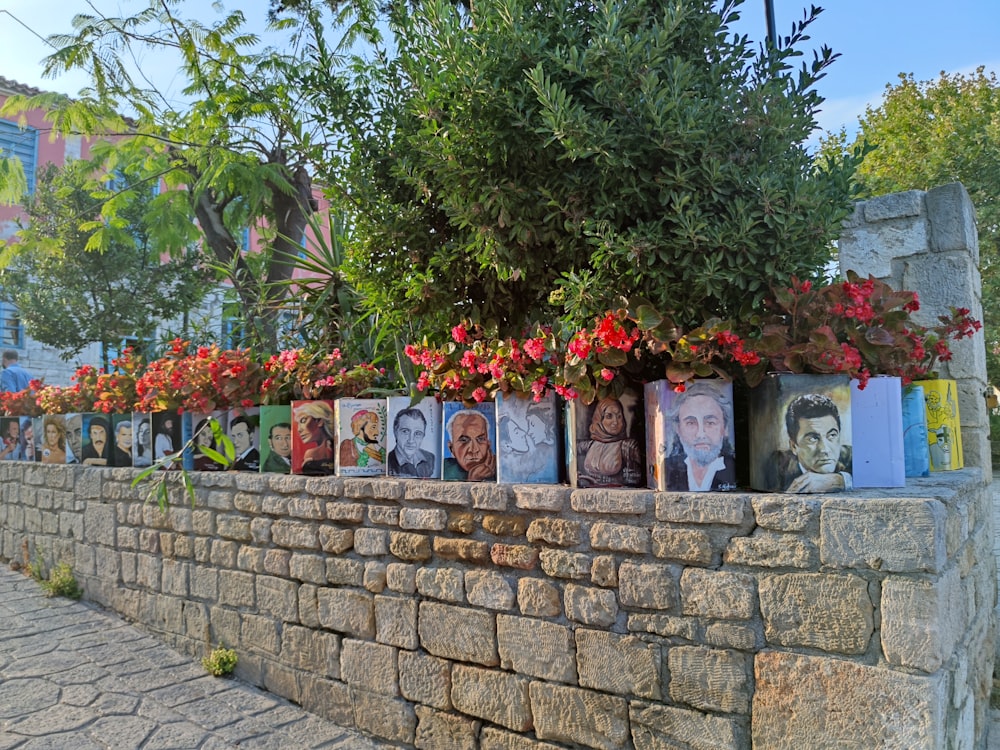 a stone wall with flowers and pictures on it