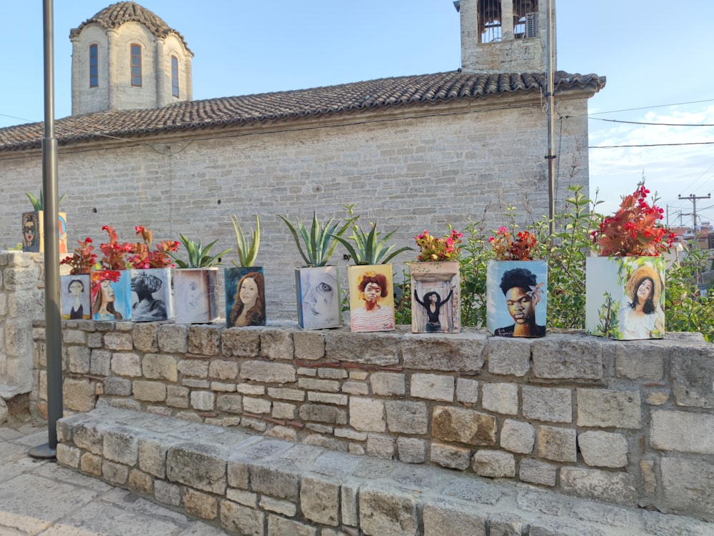 a stone wall with flowers and pictures on it