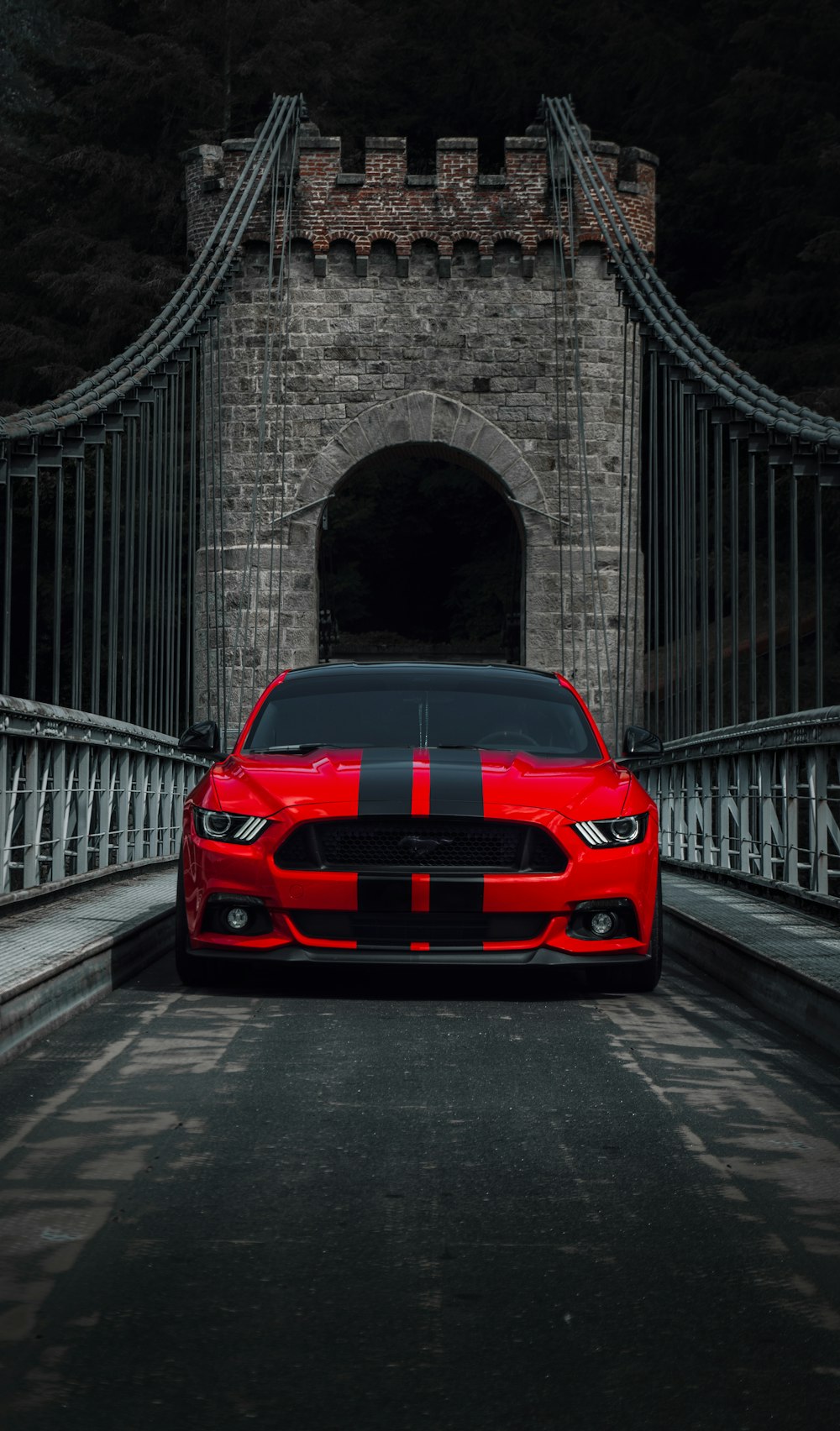 a red car is driving across a bridge