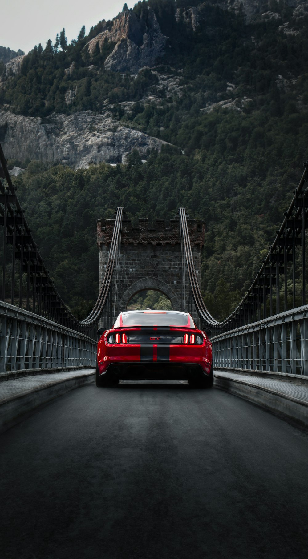 a red sports car driving across a bridge