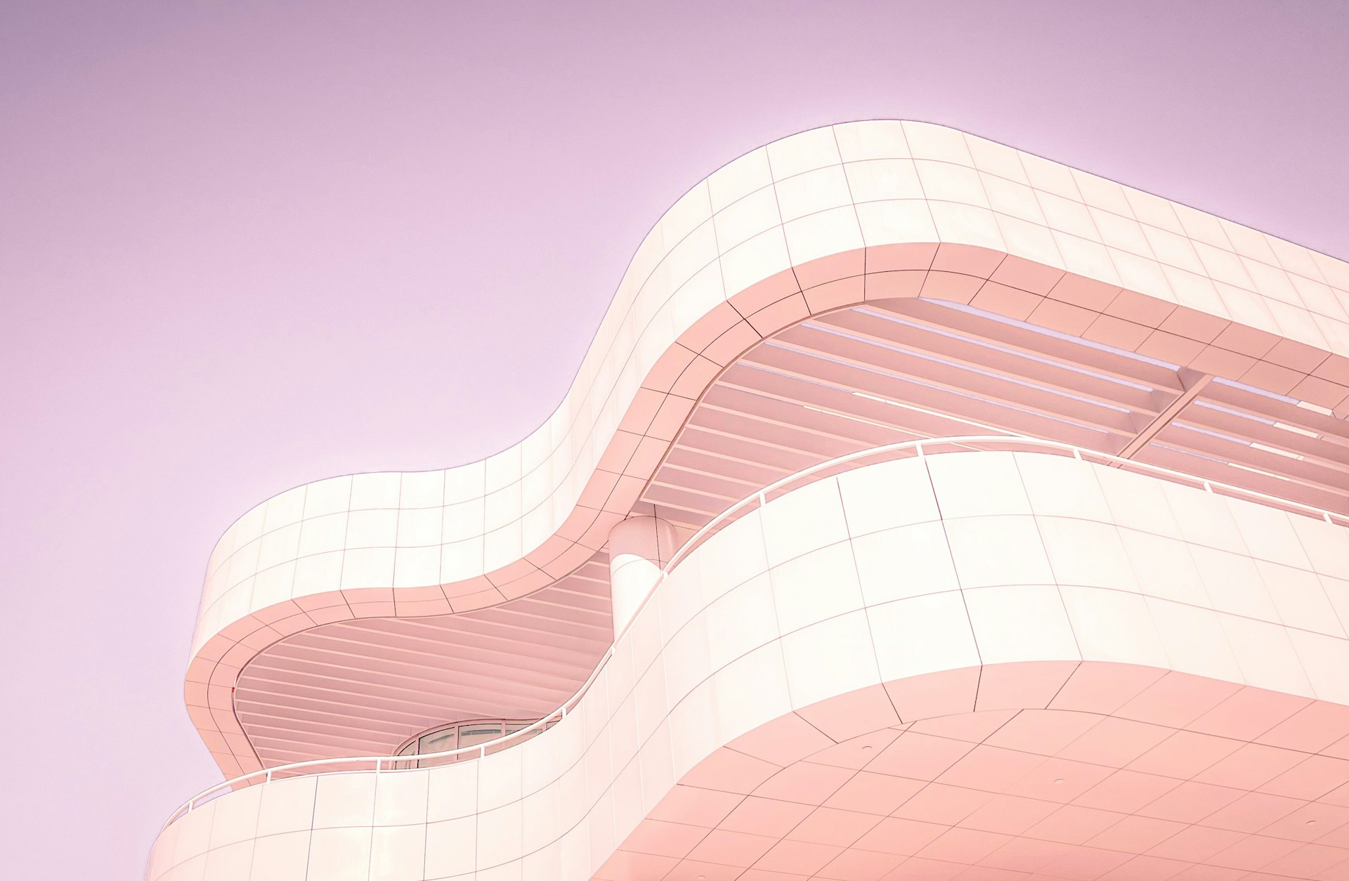 A beautifully designed modern architectural building showcasing a mix of pastel pink and beige tones.