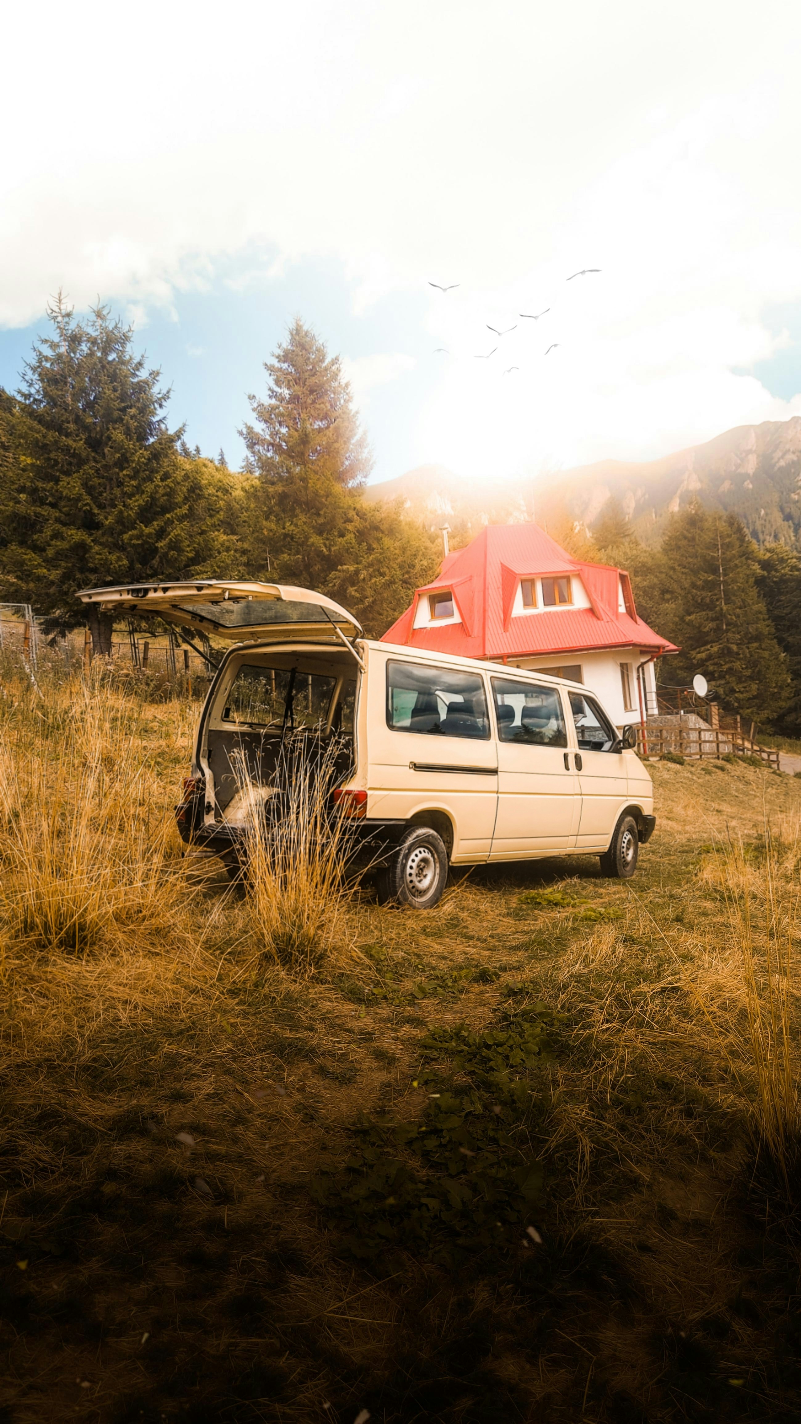 a van parked in a field with a surfboard on top of it