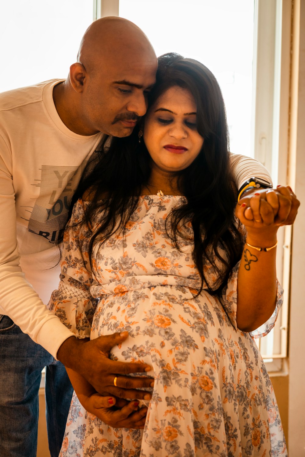 a man and a pregnant woman are looking at a cell phone