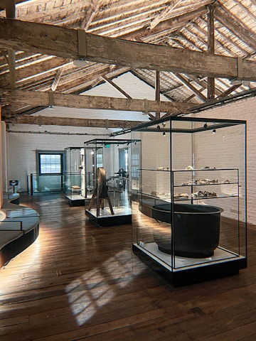 Historic artifacts displayed in a museum gallery with soft lighting