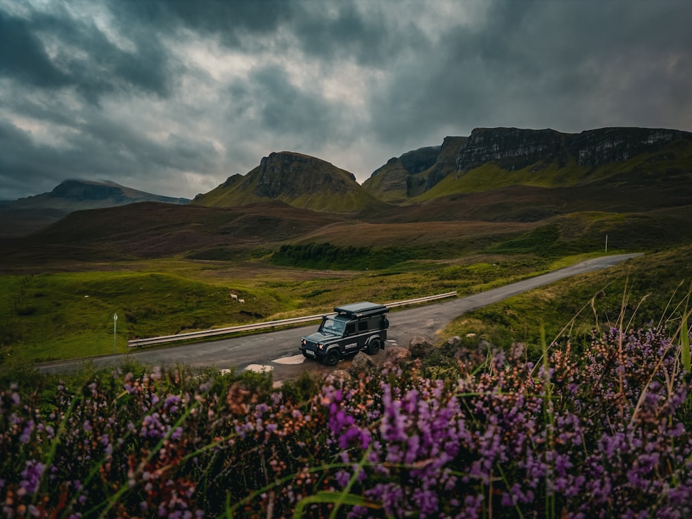 a truck driving down a road in the mountains