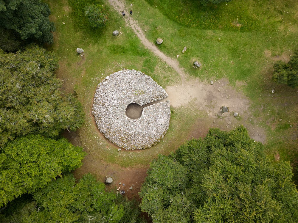 an aerial view of a large rock in the middle of a forest