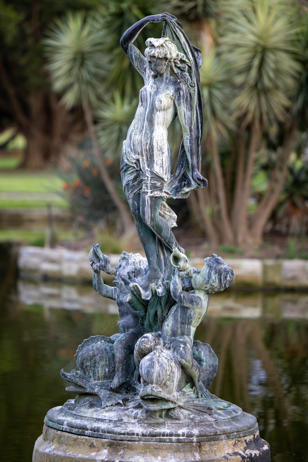 鳥を抱いた女性の像がある噴水